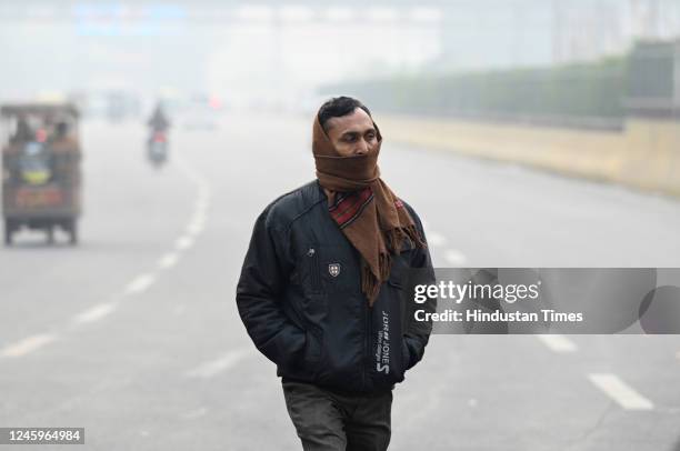 People are seen wearing warm clothes on a cold day at sector 18, dense fog blanketed the national capital region on Monday morning as the city...