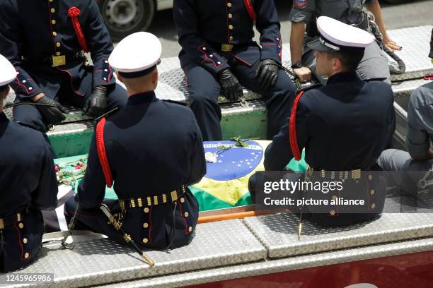 January 2023, Brazil, Santos: The coffin of the late Brazilian soccer star Pele is driven through the streets of Santos in an open car of the fire...