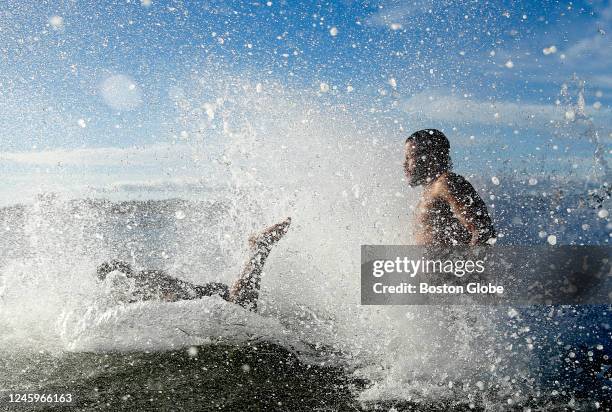 Boston, MA Plungers kicked up spray as they jumped into the ocean during the annual L Street Brownies New Year's Day Polar Plunge.