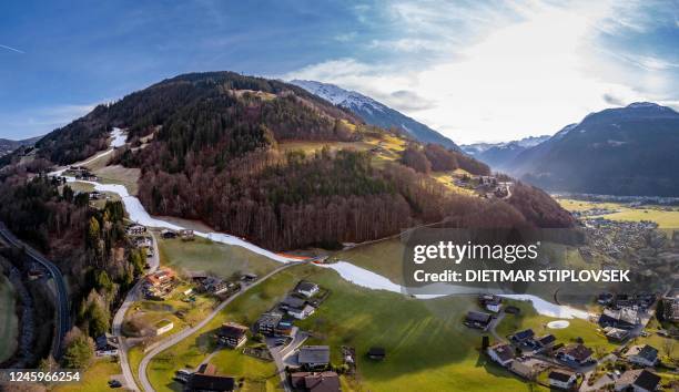 General view taken on December 28, 2022 shows a ski slope amidst green areas in Schruns, Austria. - Like other parts of Europe, Austria has...