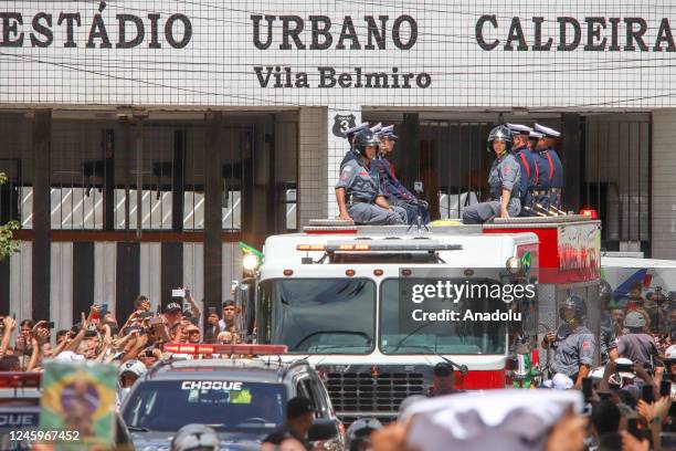 Brazilian football legend Pele being transported atop a fire truck in a funeral procession through the streets of Santos on the way to Peleâs final...