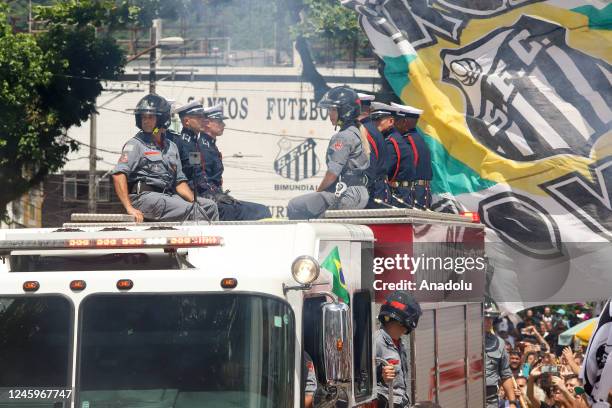 Brazilian football legend Pele being transported atop a fire truck in a funeral procession through the streets of Santos on the way to Peleâs final...