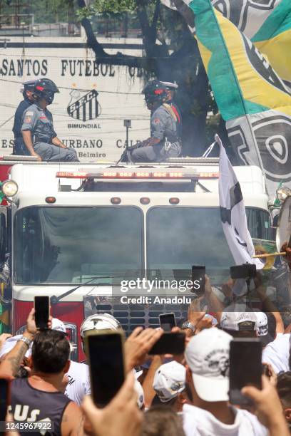 Brazilian football legend Pele being transported atop a fire truck in a funeral procession through the streets of Santos on the way to Peleâs final...