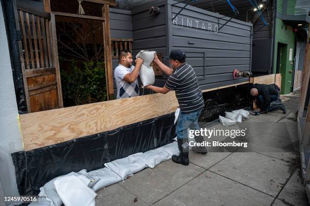 Workers build a flood protection barrier at the entrance to a business in the Mission District of San Francisco, California, US, on Tuesday, Jan. 3,...