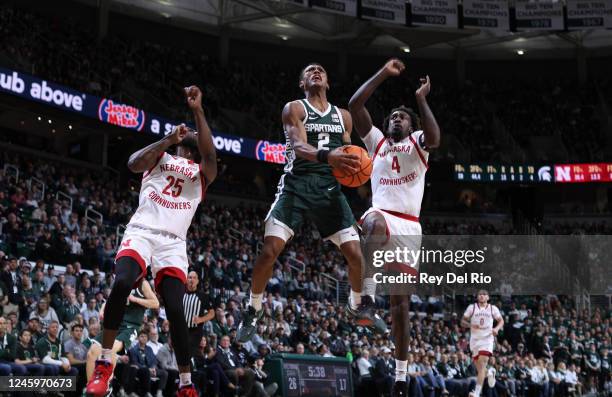 Tyson Walker of the Michigan State Spartans goes up for a layup against Ramel Lloyd Jr. #2 and Emmanuel Bandoumel of the Nebraska Cornhuskers at...