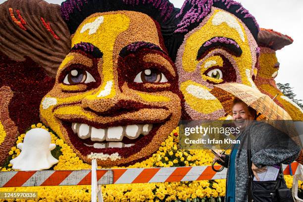 Pasadena, CA Diane Gagnon, a visitor from Montreal, Canada, stands in front of SnapChat float displayed among Rose Parade floats displayed along...