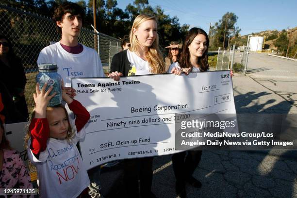 Teens Against Toxins members hold a giant check and money while waiting for a Boeing representative to speak them at the Boeing's Santa Susana Field...