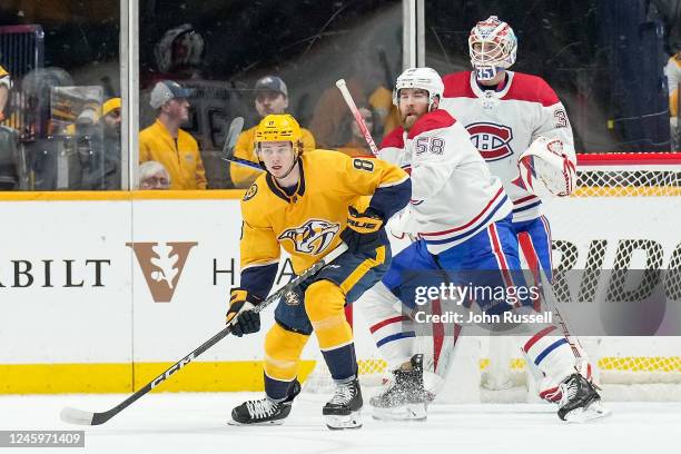 Cody Glass of the Nashville Predators battles in front of the net against David Savard and Sam Montembeault of the Montreal Canadiens during an NHL...