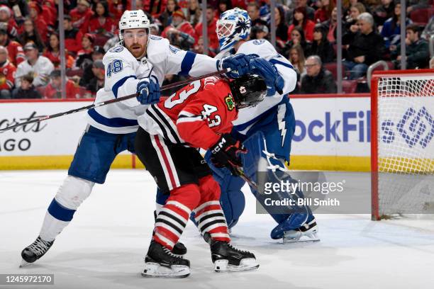 Colin Blackwell of the Chicago Blackhawks gets physical with Nick Perbix of the Tampa Bay Lightning in the first period at United Center on January...