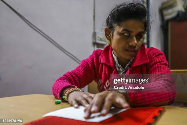 An Indian visually impaired student writes using the Braille system at a school run by the Visually Impaired Relief Association ahead of the...