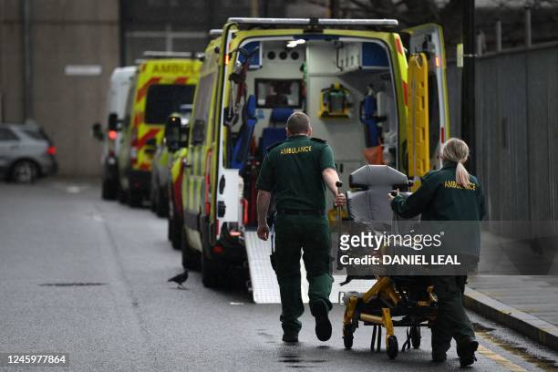 Ambulance staff push a stretcher outside the Royal London hospital in east London on January 4, 2023. - UK medical bodies said patients were dying...