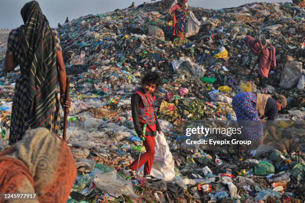 Workers working in a toxic waste dumping yard. Health risks without adequate safety where toxic substances including medical waste at garbage dump...