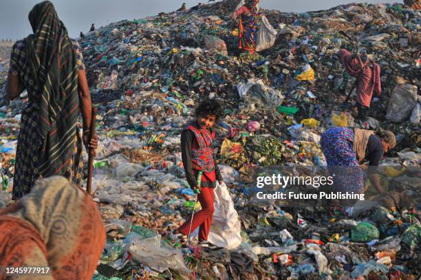 Workers working in a toxic waste dumping yard. Health risks without adequate safety where toxic substances including medical waste at garbage dump...
