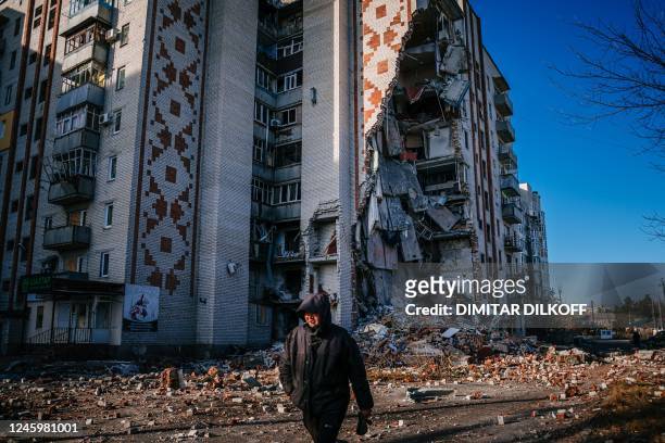 Man walks by a destroyed residential building in the city of Lyman, Donetsk region on January 4 amid the Russian invasion of Ukraine.