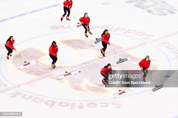 The Calgary Flames ice crew shovels snow during the first period of an NHL game between the Calgary Flames and the Vancouver Canucks on December 31...