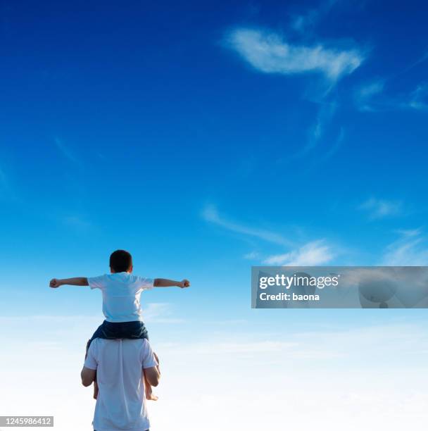 vater trägt seinen sohn auf schultern - flying dad son stock-fotos und bilder