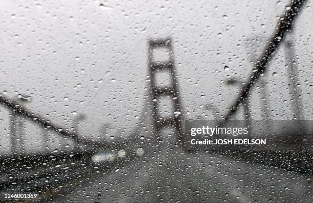 The Golden Gate Bridge is seen through a rainy windshield in San Francisco, California, on January 04, 2023. - A bomb cyclone smashed into California...