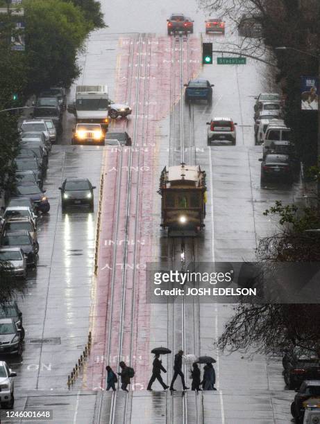 Trolly car travels down a California street during a rainstorm in San Francisco, California, on January 04, 2023. - A bomb cyclone smashed into...