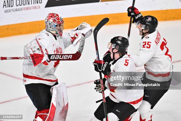 Goaltender Thomas Milic, Brandt Clarke and Kevin Korchinski of Team Canada react as they celebrate their victory against Team United States in the...