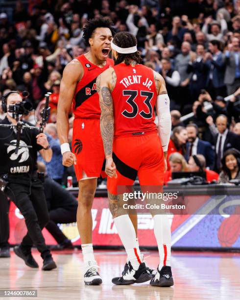 Scottie Barnes celebrates with Gary Trent Jr. #33 of the Toronto Raptors as Trent Jr. Hits a three-point shot to send their NBA game against the...