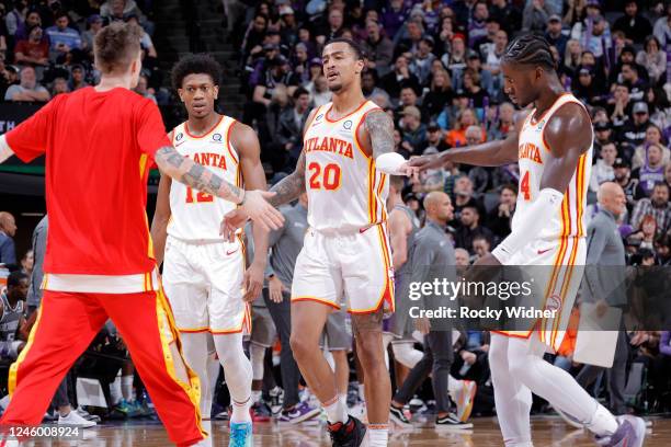 John Collins of the Atlanta Hawks high fives teammates during the game against the Sacramento Kings on January 4, 2023 at Golden 1 Center in...