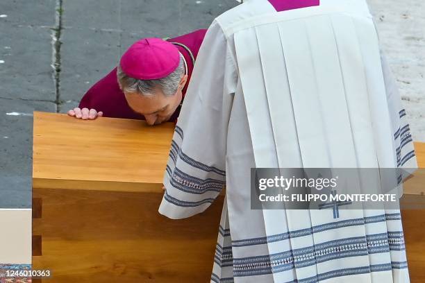 German Archbishop Georg Gaenswein kisses the coffin of Pope Emeritus Benedict XVI at the start of his funeral mass at St. Peter's square in the...