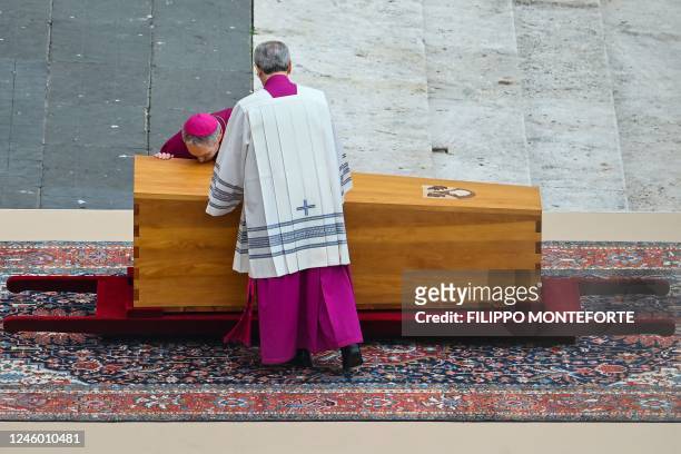 German Archbishop Georg Gaenswein kisses the coffin of Pope Emeritus Benedict XVI at the start of his funeral mass at St. Peter's square in the...