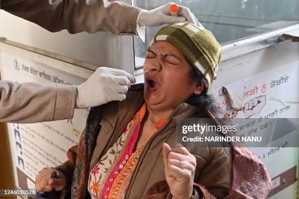 Health worker collects a nasal swab sample from a woman to test for the Covid-19 coronavirus at a hospital in Amritsar on January 5, 2023.