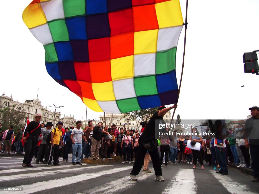 A man waving a "Wiphala", the flag of the Andean indigenous...