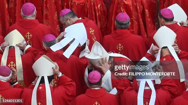 Cardinals put on their tiara during the funeral mass of Pope Emeritus Benedict XVI at St. Peter's square in the Vatican on January 5, 2023. Pope...