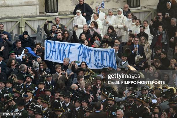 Attendees hold a banner reading in German "Thank you Pope Benedict" during the funeral mass of Pope Emeritus Benedict XVI at St. Peter's square in...