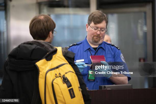 Transportation Security Administration agent checks a flyer through security at O&apos;Hare International Airport in 2019.