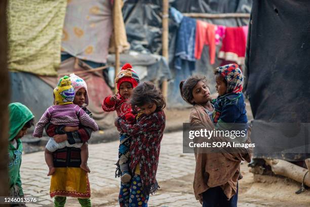 Homeless children wearing winter clothes seen playing during the cold wave in Mohan Nagar. According to the IMD , the cold wave will likely prevail...