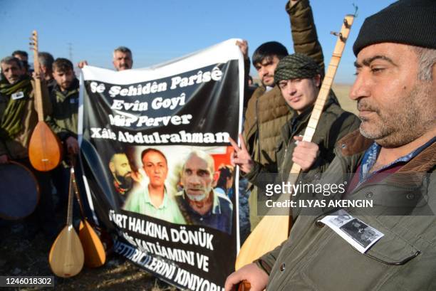 People stand behind a banner with portraits of Emine Kara , Abdurrahman Kizil and Mir Perwer , the three Kurds killed in a December 2022 attack in...