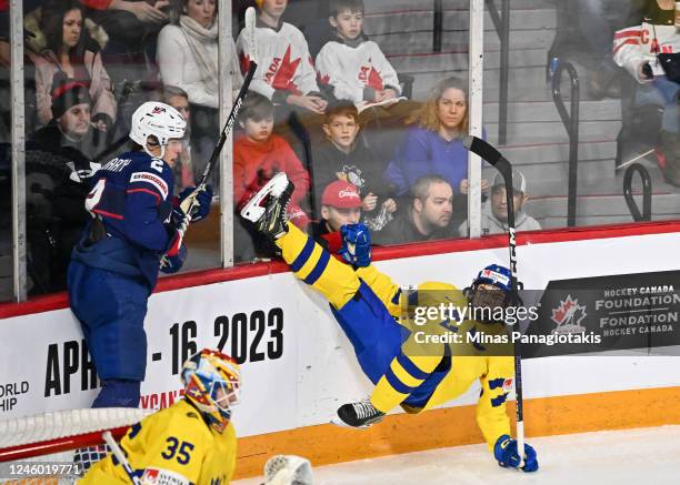 Rutger Mcgroarty of Team United States takes down Axel Sandin of Team Sweden during the first period in the bronze medal round of the 2023 IIHF World...