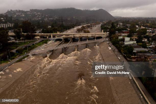 In an aerial view, the Los Angeles River flows at a powerful rate as a huge storm slams into the West Coast on January 5, 2023 in Los Angeles,...