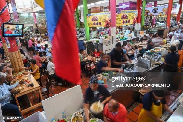 People have lunch at the food court of a market in Cali, Colombia on January 5, 2022. - Colombia registered an annual inflation of 13.1% in 2022, the...