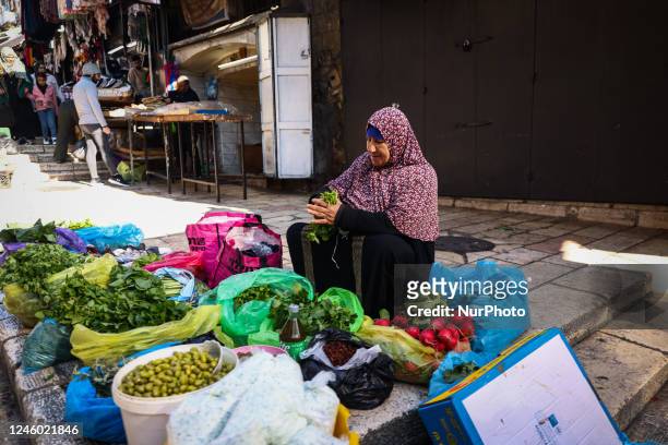 Woman sells local fresh vegetables and fruits at the street market in the Old City in Jerusalem, Israel on December 29, 2022.