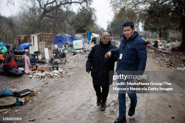 January 04: San Jose Councilmember for District 7 Bien Doan, right, holds the hand of Janet Parks Swanson who is unhoused, as he helps her leave the...