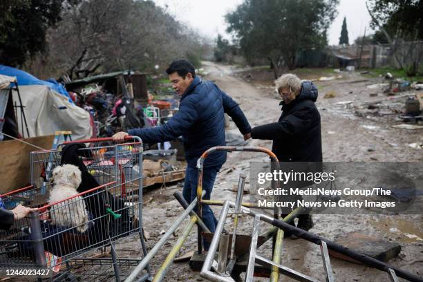 January 04: San Jose Councilmember for District 7 Bien Doan, left, holds the hand of Janet Parks Swanson who is unhoused, as he helps her leave the...