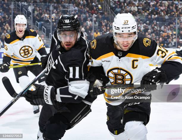 Anze Kopitar of the Los Angeles Kings and Patrice Bergeron of the Boston Bruins battle for position during the first period at Crypto.com Arena on...