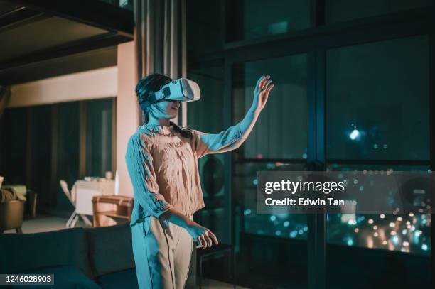 ein asiatisches chinesisches teenager-mädchen auf vr-brille und erleben 3d virtuelle spielerfahrung im wohnzimmer - 360 people stock-fotos und bilder
