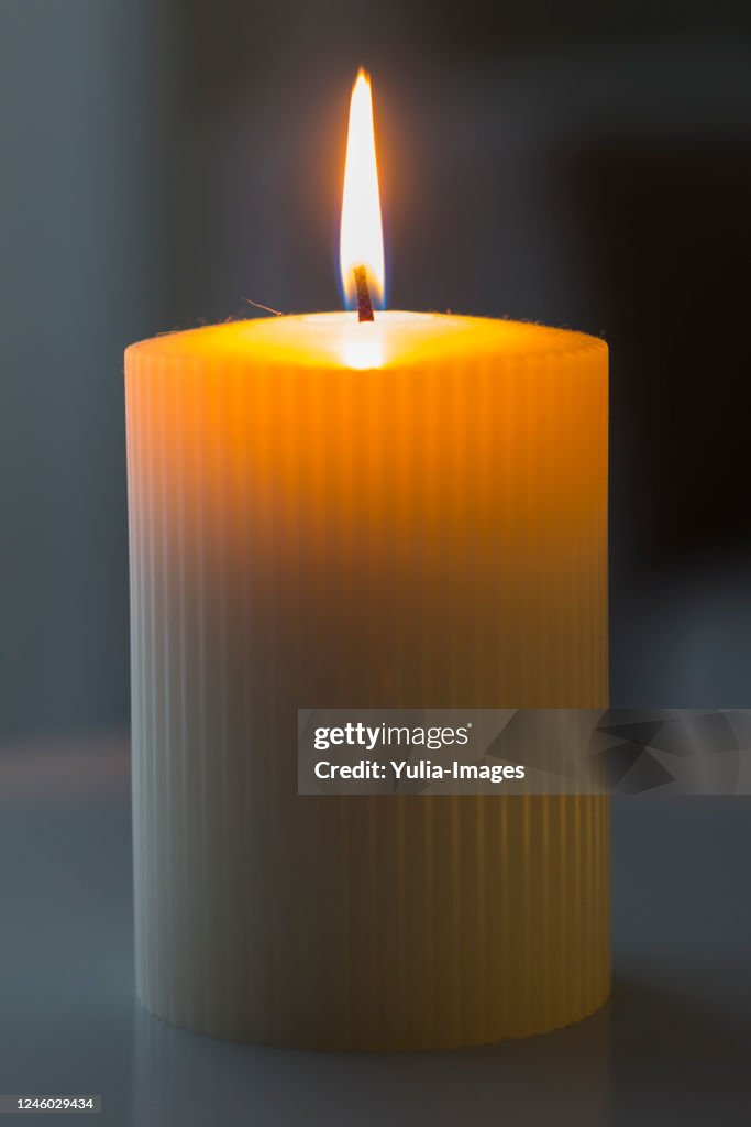 Large cylindrical burning white candle