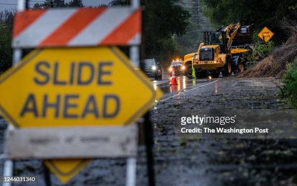 Road crew cleans a mudslide off River Road near the Russian River as a powerful storm of rain and wind arrives in Guerneville, California on...