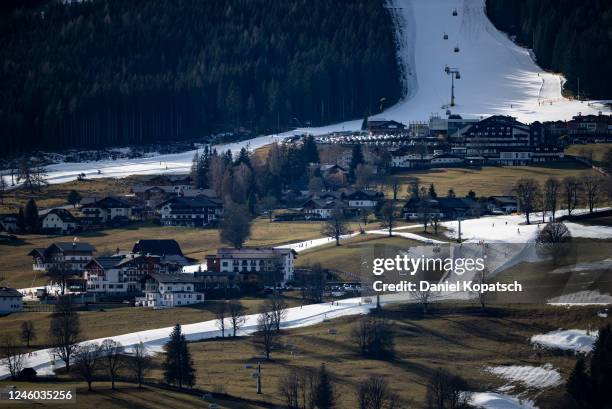 Skiers descend the slopes of the Rohrmoos skiing area covered in artificial snow as grass covers the rest of the hill on either side on January 6,...