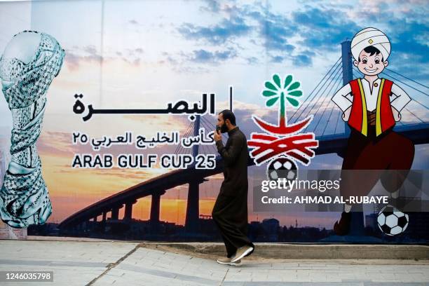 Man walks past a poster announcing the 25th Arabian Gulf Cup football championship, in the Al-Ashar district of Iraq's southern city of Basra, on...