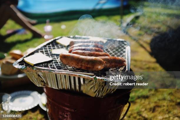 sausages on disposable bbq in back garden - slit och släng bildbanksfoton och bilder