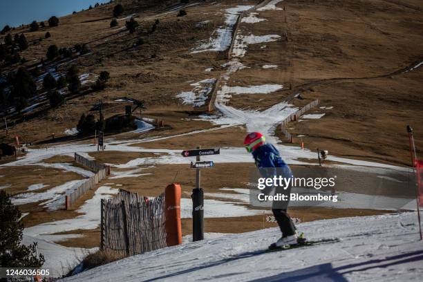 Skier heads down a narrowed run, surrounded by dry ground, at La Molina ski resort in Girona, Spain, on Thursday, Jan. 5, 2023. Warming temperatures...