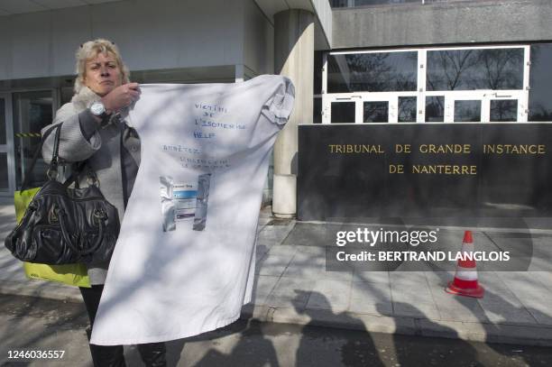 Geneviève Séré, victime du médicament Isomédrine des laboratoires Servier, présente une blouse sur laquelle elle a collé des boîtes de médicaments,...