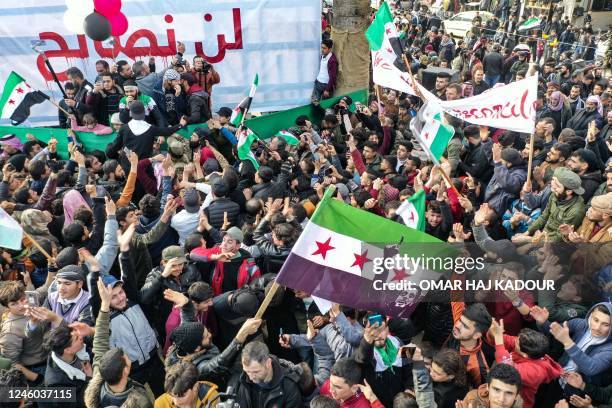 Demonstrators raise Syrian opposition flags as they rally against a potential rapprochement between Ankara and the Syrian regime, on January 6 in the...